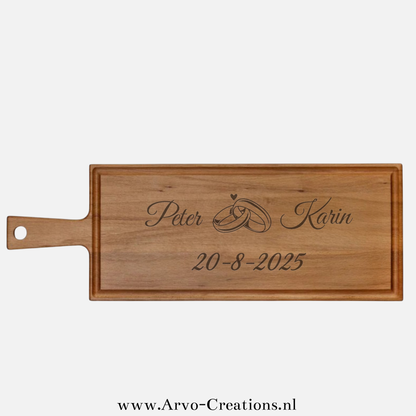 Houten borrelplank Elias met namen, trouwringen, hartje en trouwdatum – gepersonaliseerd huwelijkscadeau
Bijschrift: Borrelplank Elias met horizontale gravure: namen, ringen en trouwdatum – een uniek en persoonlijk trouwcadeau.

