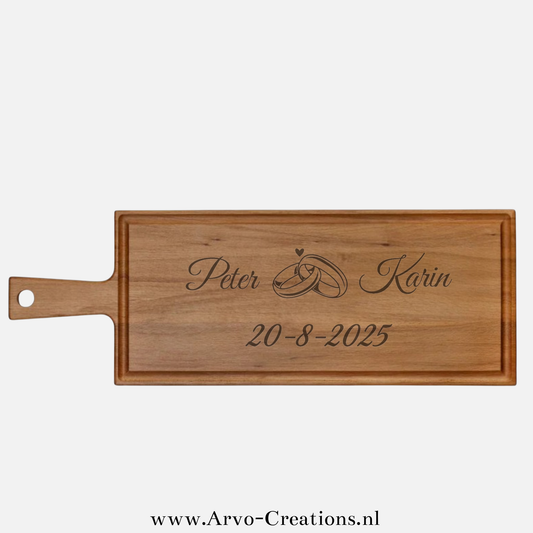 Houten borrelplank Elias met namen, trouwringen, hartje en trouwdatum – gepersonaliseerd huwelijkscadeau
Bijschrift: Borrelplank Elias met horizontale gravure: namen, ringen en trouwdatum – een uniek en persoonlijk trouwcadeau.
